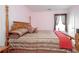 Charming bedroom with a four-poster bed, soft pink walls, and large window at 1009 S Creek Dr, Villa Rica, GA 30180