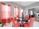 Cozy dining area with a black table, red chairs, and natural light from the windows with sheer red curtains at 1009 S Creek Dr, Villa Rica, GA 30180