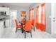 Cozy dining area with a black table, orange chairs, and natural light from the windows with sheer orange curtains at 1009 S Creek Dr, Villa Rica, GA 30180