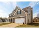 Side view of a two-story home with a large garage, well-maintained lawn, and a classic design at 1009 S Creek Dr, Villa Rica, GA 30180