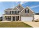 Charming two-story home with stone accents, attached garage, inviting porch and manicured lawn at 1009 S Creek Dr, Villa Rica, GA 30180