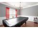 Well lit game room features a covered pool table, crown molding, and red curtain accents at 1009 S Creek Dr, Villa Rica, GA 30180
