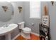Tastefully decorated half bathroom includes a pedestal sink and decorative wall hangings at 1009 S Creek Dr, Villa Rica, GA 30180