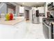 Modern kitchen featuring stainless steel appliances, white cabinets, countertops, and stylish white marble-look flooring at 1009 S Creek Dr, Villa Rica, GA 30180
