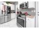 Modern kitchen featuring stainless steel appliances, white cabinets, countertops, and stylish white marble-look flooring at 1009 S Creek Dr, Villa Rica, GA 30180