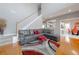 Open living room with a gray leather sofa, red accents, hardwood floors, and a staircase at 1009 S Creek Dr, Villa Rica, GA 30180