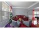 Cozy living room featuring a red sofa, gray chairs, and a festive Christmas tree by the window at 1009 S Creek Dr, Villa Rica, GA 30180