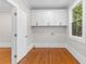 Laundry room featuring wooden floors, white cabinets, and natural light at 159 Forest Ave, Social Circle, GA 30025