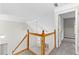 Upstairs hallway with wooden railing and carpet, with view into the downstairs living area at 2443 High Meadows Ct, Conyers, GA 30094