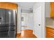 The kitchen area with stainless steel refrigerator, and hardwood floors leads to the exterior and laundry room at 2443 High Meadows Ct, Conyers, GA 30094