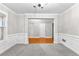 A bright living room features gray carpet, white walls, white trim, and entry to a room with hardwood flooring at 2443 High Meadows Ct, Conyers, GA 30094