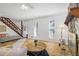 Open-concept living room with a stone fireplace, hardwood floors, and staircase to upper level at 3798 Valley Brook Rd, Snellville, GA 30039