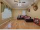 Cozy living room featuring hardwood floors, decorative ceiling fan, and large windows at 815 Lake Stone Lea Dr, Oxford, GA 30054