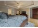 Comfortable main bedroom showcasing tray ceilings, fan, and a king-size bed at 815 Lake Stone Lea Dr, Oxford, GA 30054
