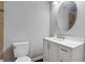 Bright bathroom featuring a white vanity with modern fixtures, a toilet, and a round mirror at 819 Forrest Se Cir, Atlanta, GA 30354