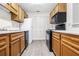 A well-lit kitchen featuring wooden cabinets, black appliances, and white countertops at 1205 Gettysburg Pl, Sandy Springs, GA 30350