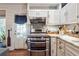 White farmhouse-style kitchen with a stainless steel oven range, marble countertops and wooden floors at 4828 Lakewood Dr, Acworth, GA 30101