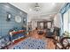 Open-concept living area with hardwood floors, a stylish blue accent wall, and a comfortable seating area at 4828 Lakewood Dr, Acworth, GA 30101