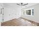 A bedroom featuring hardwood floors, bay window, and three doors to closets and hallways at 5915 Trent Walk Dr, Lithonia, GA 30038