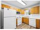 Cozy kitchen features white appliances, wood cabinets, and hardwood style floor at 5915 Trent Walk Dr, Lithonia, GA 30038