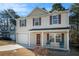 Inviting two-story home featuring a covered front porch and an attached one-car garage at 5987 Westchase St, Atlanta, GA 30336