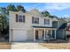 Desirable two-story home boasting a cozy front porch, attached garage and manicured lawn at 5987 Westchase St, Atlanta, GA 30336
