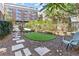 Landscaped backyard with an artificial turf area, stone pavers, and a wooden Adirondack chair at 650 Glen Iris Ne Dr # 15, Atlanta, GA 30308