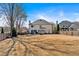 Expansive backyard view of a two-story home with a large grassy area, privacy fence, and patio at 10780 S Kimball Bridge Xing, Alpharetta, GA 30022