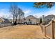 Large backyard view of a two-story home with a large grassy area, privacy fence, and patio at 10780 S Kimball Bridge Xing, Alpharetta, GA 30022