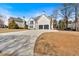 Inviting home exterior featuring a long driveway, spacious lawn, and trees in the front yard and side yard at 10780 S Kimball Bridge Xing, Alpharetta, GA 30022