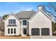 Charming home with light-colored brick, dark shutters, arched window over the front door, and a two car garage at 10780 S Kimball Bridge Xing, Alpharetta, GA 30022
