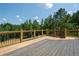 Large wooden deck with black metal railings overlooks the backyard and surrounding trees at 112 Dallas Mark Drive, Canton, GA 30115