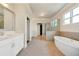 Luxurious bathroom featuring a soaking tub, a glass-enclosed shower, and double vanity sinks with marble countertops at 112 Dallas Mark Drive, Canton, GA 30115
