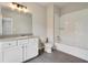 Well-lit bathroom featuring a tiled floor, vanity, toilet, and tub with white subway tile surround at 112 Dallas Mark Drive, Canton, GA 30115