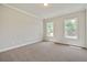 Spacious bedroom featuring neutral carpet, crown molding, and abundant natural light from two large windows at 112 Dallas Mark Drive, Canton, GA 30115