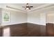 Spacious bedroom featuring dark wood floors, a ceiling fan, and ample natural light from a large window at 112 Dallas Mark Drive, Canton, GA 30115