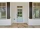 Charming light blue front door with glass panels, framed by dark shutters and stone flooring at 112 Dallas Mark Drive, Canton, GA 30115