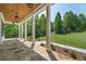 Inviting covered porch with stone flooring, wood ceiling and view of the lush green lawn at 112 Dallas Mark Drive, Canton, GA 30115