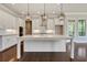 Bright, open kitchen featuring white cabinets, a large island with marble countertop, and stylish pendant lighting at 112 Dallas Mark Drive, Canton, GA 30115