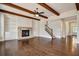 Open-concept living room with stone fireplace, built-in shelving, hardwood floors, and natural wood beam ceiling at 112 Dallas Mark Drive, Canton, GA 30115
