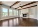 Bright living room features a stone fireplace, wood beams, hardwood floors, and large windows with natural light at 112 Dallas Mark Drive, Canton, GA 30115