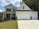 Charming two-story home with a three-car garage, stone accents, and a well-manicured lawn at 385 Riverwood Pass, Dallas, GA 30157