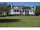 An impressive two-story home with a metal roof and a large lawn, surrounded by a black fence at 385 Riverwood Pass, Dallas, GA 30157