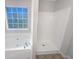 Bathroom with separate tub and shower featuring a window for natural light at 405 Willow Shoals Dr, Covington, GA 30016