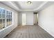 Bedroom with a tray ceiling, large window, and neutral carpet at 405 Willow Shoals Dr, Covington, GA 30016