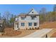 Inviting two-story home with gray siding, brick accents, and a long driveway, nestled on a sloped lot at 731 Crest Line W Trl, Powder Springs, GA 30127