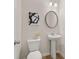 Powder room includes a pedestal sink, round mirror and neutral color scheme create a clean and functional space at 228 Epping Street # 8, Stockbridge, GA 30281