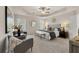 This is a bedroom with neutral colored walls, carpet, tray ceilings, and a ceiling fan at 228 Epping Street # 8, Stockbridge, GA 30281