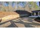 Backyard featuring mature trees, retaining wall, and walkout access from the home at 6650 Canyon Cv, Cumming, GA 30028
