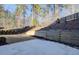 Landscaped backyard with concrete patio, retaining wall, and mature trees at 6650 Canyon Cv, Cumming, GA 30028